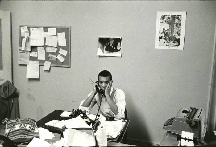 Ivanhoe Donaldson sits behind a desk with a phone to his ear and his head resting in his hands.
